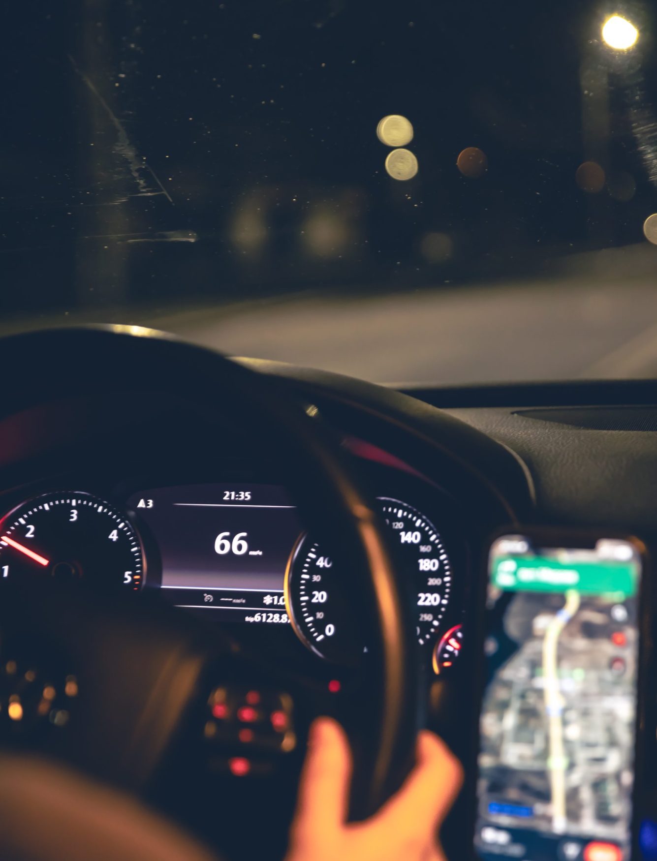Close-up, steering wheel and navigator in a car at night. Close-up, steering wheel and navigator in a car at night. Driving at night, close-up of the steering wheel.